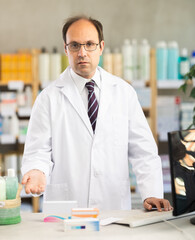 Portrait of male pharmacist inviting to visit modern drugstore