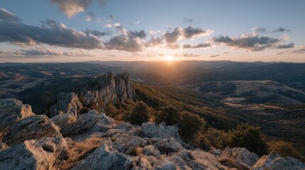 Obraz premium Stunning sunset over a mountain range with a beautiful sky and rocky foreground