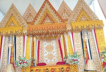Traditional wedding decorations with gold embroidery, vibrant fabrics, and floral accents,...