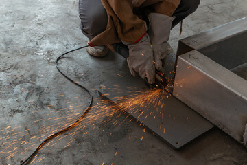 skilled worker cutting an iron pipe with a grinder