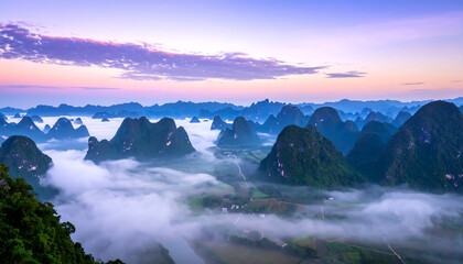 Serene Sunrise Over Misty Karst Mountains: Breathtaking Panoramic View of Lush Green Valley and Rolling Hills at Dawn.