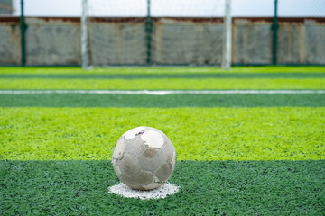 an old soccer on the penalty spot on a soccer field at horizontal composition
