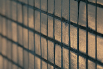 Close-up of light tiled surface with diagonal window shadows, golden sunlight, geometric grid...