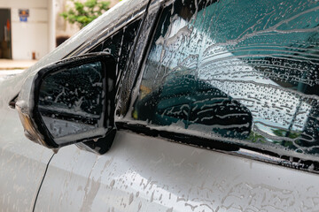 washing a car with soapy water at horizontal composition