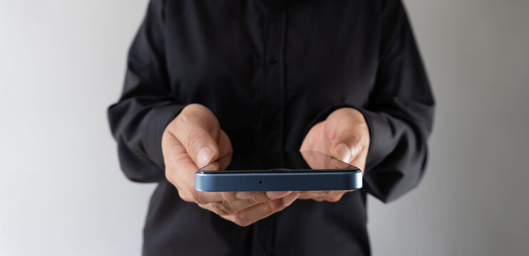 Businesswoman wearing black blouse, holding a cell phone - Powered by Adobe