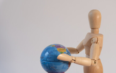 A wooden mannequin with a small globe