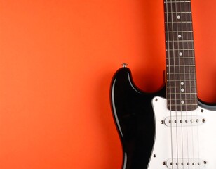 Black electric guitar on orange background
