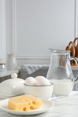 Different dairy products and eggs on white marble table indoors. Space for text