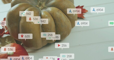 Social media interaction icons image over autumn pumpkins and leaves on white surface