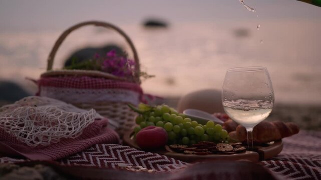 summer picnic at sunset on beach with wine
