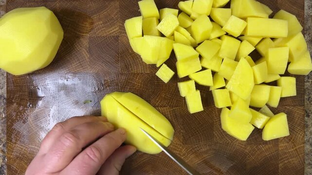 chef chops potatoes with a knife.