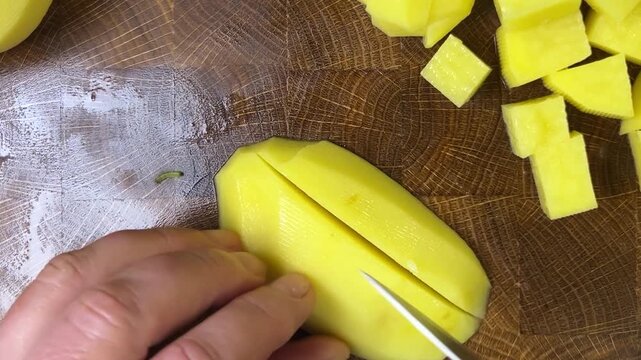 chef chops potatoes with a knife.