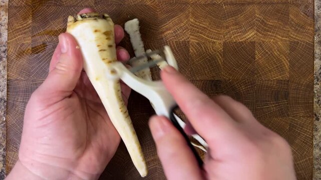 woman peeling parsley root with peeler.