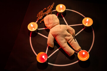 Voodoo doll on a pentagram. Witch spells.