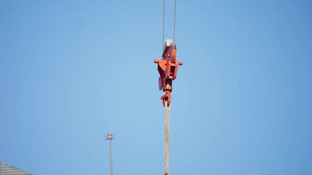 Crane and building under construction against blue sky