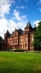 Obraz premium Architectural view of a large brick building with a grassy lawn