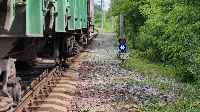 Stationary Railway cars on shunting tracks against the background of a blue traffic light
