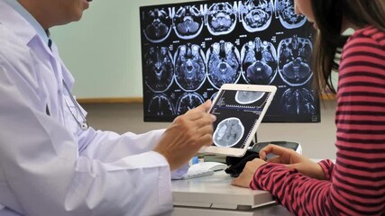patient looking at skull x ray on tablet with doctor. doctor explaining the results of skull x-ray with patient. modern digital technology in hospital concept. - Powered by Adobe