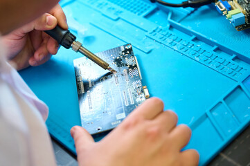 Soldering electronic components on a circuit board during a workshop in a classroom environment