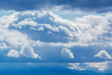View of cloudy weather with three small light clouds