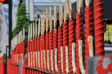 red and white metallic fence posts in a row
