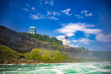 The gushing turquoise water from the Niagara falls with blue sky and white clouds the beautify scenry of nature