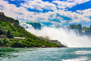 The gushing turquoise water from the Niagara falls with blue sky and white clouds the beautify scenry of nature