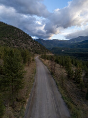 Winding Road Through Forested Canadian Mountains Under Cloudy Sky