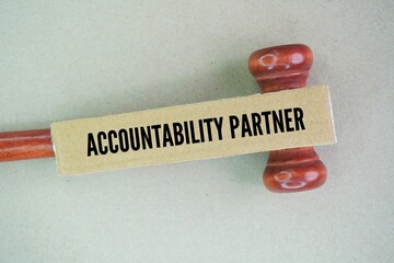 Judge's hammer and paper with the word accountability partner. someone who supports another person...