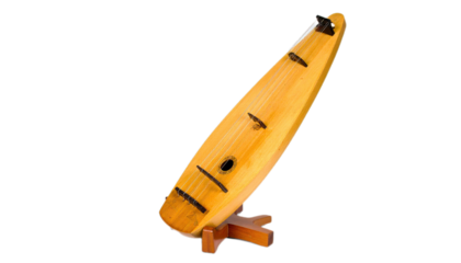 A light-brown wooden instrument, a traditional stringed instrument, stands angled on a dark background.