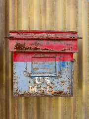 Close Up of an Old Red and Blue U.S. Mail Box with Chipped Paint