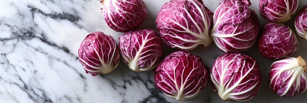 Fresh, vibrant red radicchio heads arranged on a marble surface
