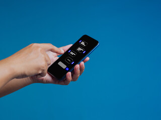 Hand using smartphone with chatbot interface on blue background showing AI messaging and communication.