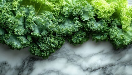Fresh kale leaves, vibrant green and lime green, lie on a marbled surface