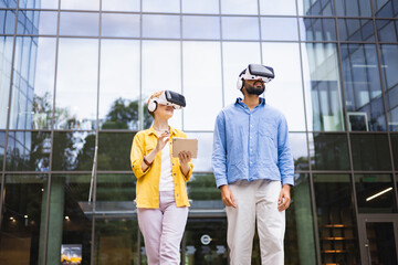 Two people wearing VR headsets explore augmented reality outdoors, near a modern glass building,...