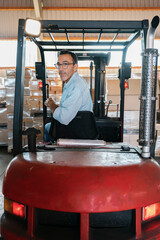 Warehouse worker driving forklift in logistics center