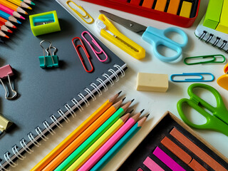 Assorted school supplies are arranged on a white surface