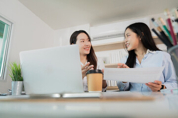 Collaborative Meeting. Two women discussing financial reports in a modern office.