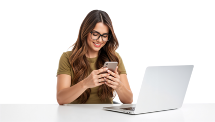 Smiling woman browsing her smartphone while sitting at a desk with a laptop