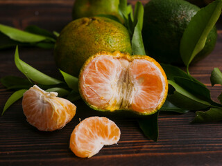 Jeruk keprok, fresh tangerines with green leaves on wooden table, fresh orange fruit, ripe...