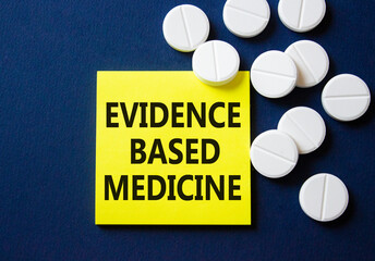 Evidence Based Medicine symbol. Concept word Evidence Based Medicine on yellow note. Beautiful deep blue background with pills. Medicine and Evidence Based Medicine concept. Copy space