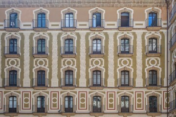 Ornate Baroque Facade With Symmetrical Windows And Iron Balconies At Montserrat Basilica Complex. Classical architecture, decorative stonework, religious building, pilgrimage destination