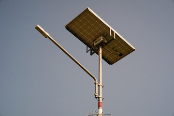 Low-angle shot of solar panel technology on a street light pole. Electricity poles with...