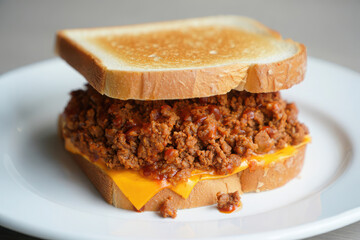 Delicious sloppy joe sandwich with melted cheese on white bread
