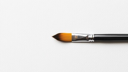 Naklejka premium Minimalist paintbrush lying on textured white surface in studio