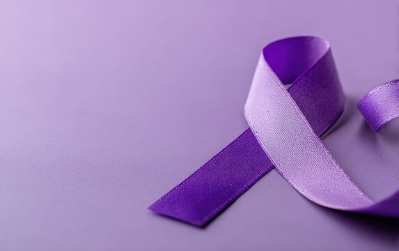 Purple epilepsy awareness ribbon lying on a purple background, representing support for epilepsy, seizures, and related neurological conditions