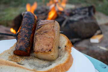 Traditional Hungarian outdoor grilling with bread, bacon and sausage