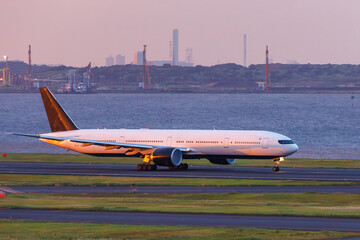 夕焼けの羽田空港のデッキ。
離発着する旅客機と夕暮れの東京の町並みが見える。
東京都大田区東京国際空港（羽田空港）-2025/6/26
