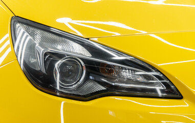 BI-LED headlights of a modern and expensive yellow car. Front BI-LED headlight on a yellow sport...