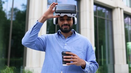 A smiling man holds a VR headset and a coffee cup, set against a modern building. - Powered by Adobe